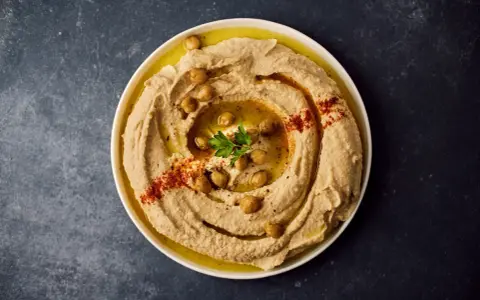 Krämig hummus med kikärtor, olivolja och paprikapulver. Ett perfekt hummus recept för alla tillfällen.