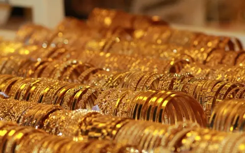 Una ricca collezione di bracciali d'oro, molti con il marchio 750, brillano sotto la luce, creando un'abbagliante esposizione di lusso.