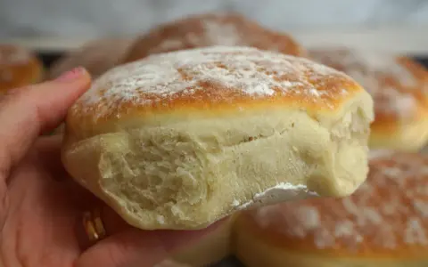 En hand håller en nybakad tekaka, pudrad med mjöl. Perfekt för ett enkelt tekakor recept.