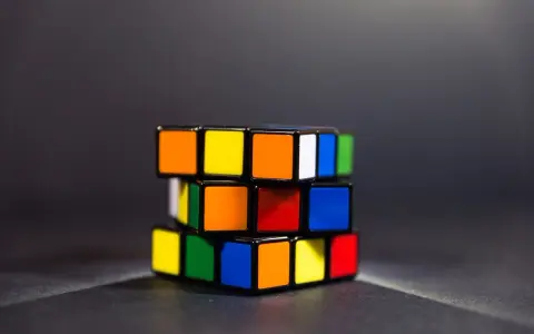 En färgglad speed cube ligger på ett mörkt underlag.
