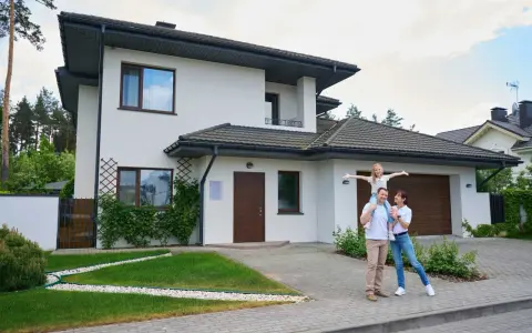Rodzina przed nowoczesnym domem. Zastanawiasz się, ile realnie kosztuje budowa domu?