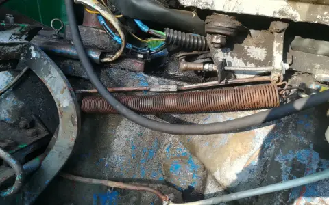 Widok na mechanizm cięgna gazu c 360 z widocznymi sprężynami, przewodami i elementami mocowania.