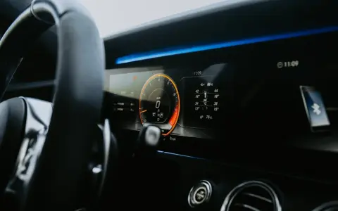 Cyfrowy kokpit pokazuje 0 km/h, wskazując na falujące obroty na zimnym silniku diesel. Wskaźniki temperatury i ciśnienia są widoczne.