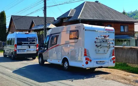 Dwa kampery zaparkowane na drodze w Rumunii, gotowe na przygodę.