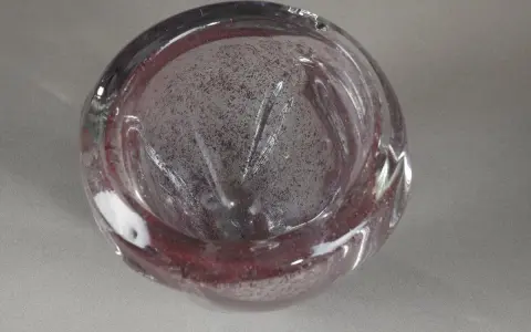 Un bol en verre soufflé, aux reflets pourpres et inclusions, évoquant l'art de André Thuret.