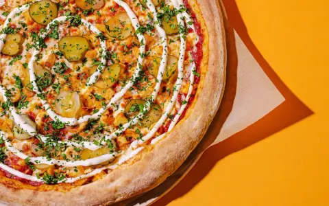 Apetyczna pizza z ogórkiem i sosem, idealna na szybki posiłek. Zastanawiasz się, ile kosztuje pizza we Włoszech?