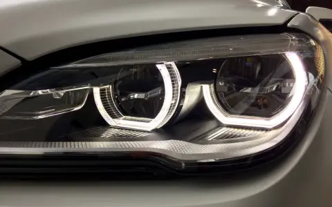 Nahaufnahme eines modernen Autoscheinwerfers mit leuchtendem Standlicht.