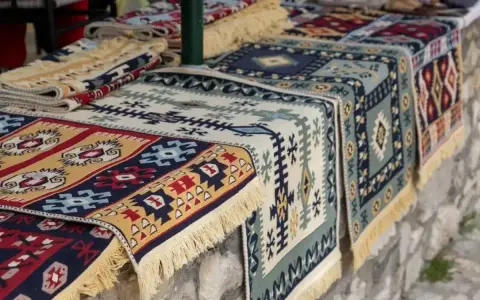 Kolorowe, tradycyjne kilimy z frędzlami. Idealne pamiątki, by poczuć klimat Albanii. Co przywieźć z Albanii? Taki kilim!