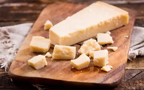 Parmesan-Stücke auf Holzbrett. So einfach kann parmesan einfrieren sein, um den Geschmack zu bewahren.