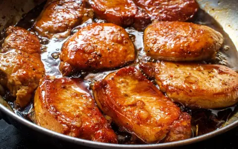 Filet mignon en train de dorer dans une poêle, leur marinade caramélisée créant une sauce appétissante.