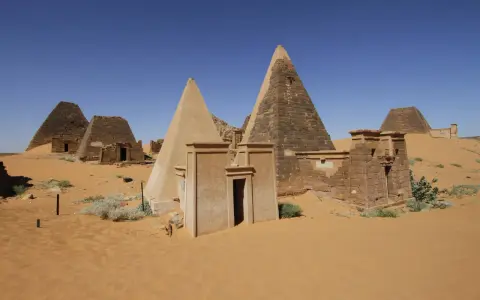Niezwykłe piramidy w Meroe, fascynujące miejsca na sudan wycieczki. Piasek pustyni otacza starożytne budowle.