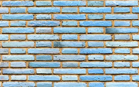 Textura de ladrillo visto pintado de azul claro, con juntas de mortero amarillentas.