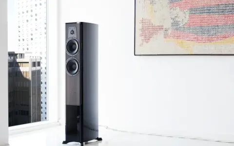 Elegancki głośnik Dynaudio Contour 30 w nowoczesnym wnętrzu, obok okna z widokiem na miasto.
