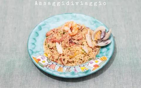 Un saporito cous cous di pesce con gamberi, polpo e cozze, servito su un piatto decorato.
