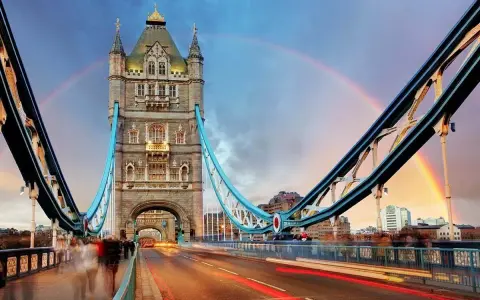 Tower Bridge in London, a city renowned for its art, glows under a double rainbow at dusk.