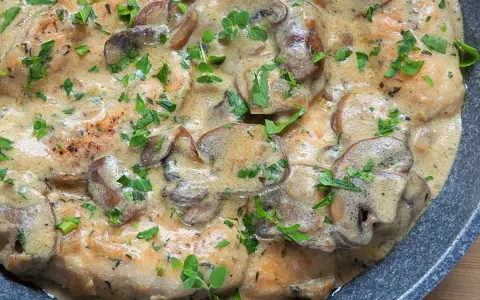 Polędwiczki w sosie pieczarkowym, kremowe i aromatyczne, posypane świeżą natką pietruszki.