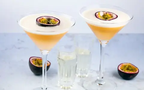 Dwa drinki Pornstar Martini, ozdobione połówką marakui, z kieliszkami z dodatkowym shotem. Idealne, by dowiedzieć się, jak pić.