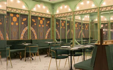 Elegante restaurante con mesas y sillas verdes, paredes decoradas con girasoles y detalles dorados. Un lugar perfecto para disfrutar de **frases restaurante** inspiradoras.