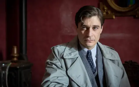 Il commissario Ricciardi, con il suo trench e lo sguardo pensieroso, pronto a risolvere i misteri dei libri in ordine cronologico.