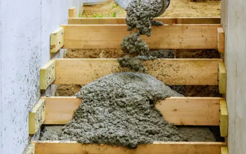 Vertido de hormigón fresco en el armado de una escalera de madera.