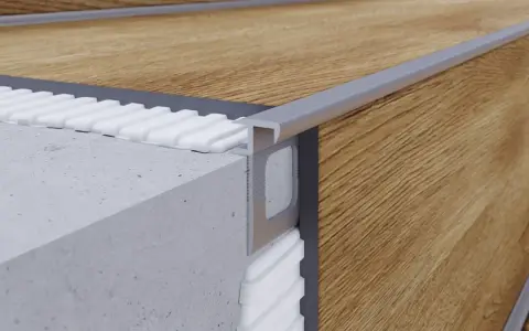 Zbliżenie na schody z paneli drewnianych, z widocznym profilem aluminiowym i warstwą izolacyjną.