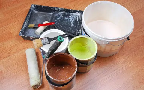 Attrezzi per pittura e barattoli di vernice avanzata, pronti per essere conservati.