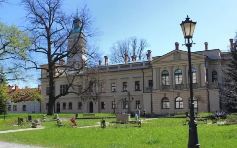 Zamek w Żywcu, z wieżą i dziedzińcem, otoczony zielenią i drzewami.
