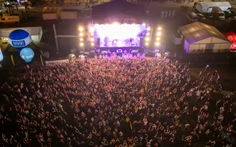 Tłum ludzi na koncercie podczas Cieszynów Rock Festiwal. Na scenie gra zespół, a przed nią tysiące fanów.