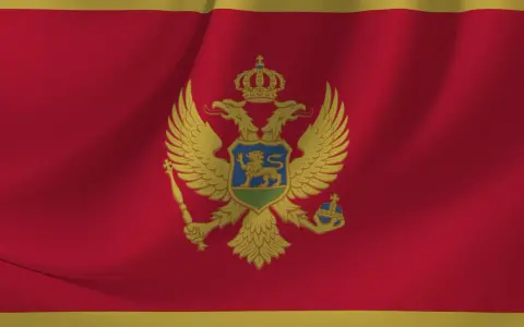 Flaga Czarnogóry z dwugłowym orłem i tarczą herbową. Symbol dumy narodowej, który można zobaczyć podczas podróży do tego pięknego kraju.