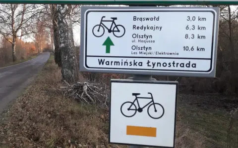 Znak drogowy informuje o odległościach do Brąswałd, Redykajn, Olsztyna i Lasu Miejskiego. To część szlaku Warmińska Łynostrada.
