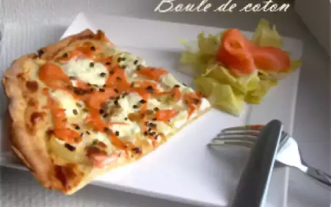 Une part de flamenkuch saumon, garnie de fromage frais et d'aneth, accompagnée d'une salade verte et de saumon fumé.