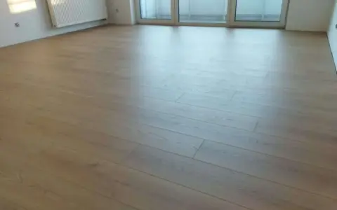Jasne panele ułożone równolegle do okna, tworząc jasną i przestronną przestrzeń.