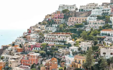 Colorful houses cascade down a hillside towards the sea, a picturesque scene perfect for any Europe itinerary.
