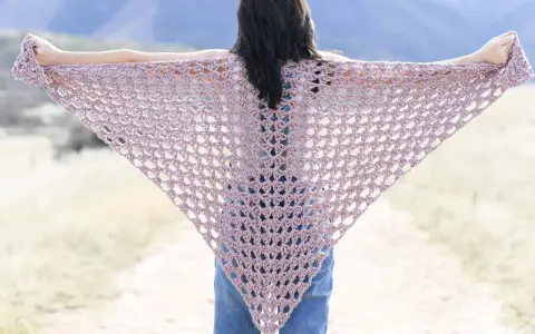 Chal triangular de crochet en tono rosa pálido, ideal para un patrón chal crochet facil.