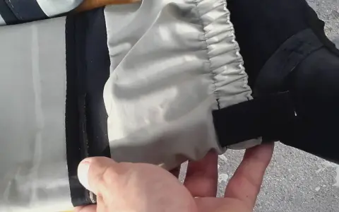 Hand hält ein Hosenbein mit elastischem Bund und Klettverschluss. Vielleicht ein Flicken für die wathose?