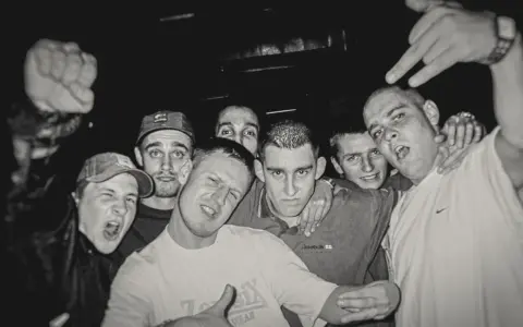HZOP feat. Dudek RPK & RPS - każdy z nas. Grupa młodych mężczyzn pozuje do zdjęcia, jeden z nich pokazuje znak rock'n'rolla.