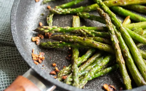 Asparagi in padella, croccanti e saporiti, con pezzetti di pancetta tostata che aggiungono un tocco in più.