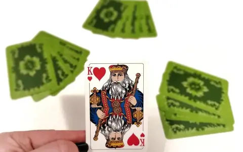 Król kier, a za nim stos zielonych kart. Czyżby to była gra w "Dupa biskupa"?