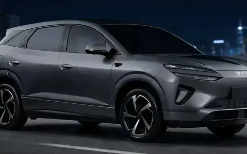 Szary samochód elektryczny BYD na tle nocnego miasta.