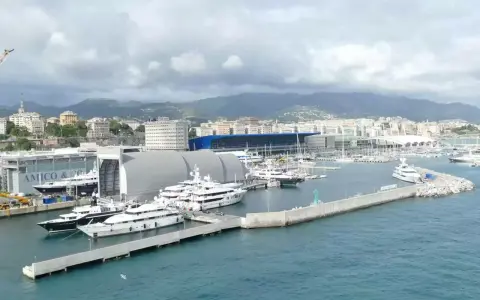 Porto con yacht di lusso ormeggiati, sullo sfondo la città e le montagne. Un'immagine che fa sognare, ma il costo medio crociera è da valutare.