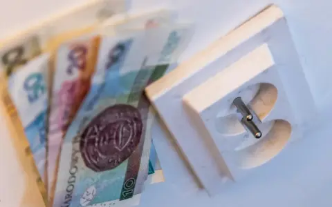 Pieniądze leżą obok gniazdka elektrycznego. Czy to symbolizuje pge brak faktury i rachunków do zapłaty?