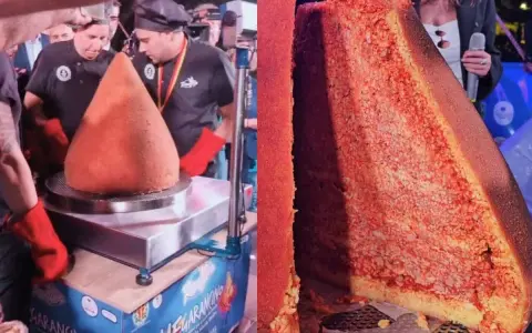 A giant arancino is presented, with a slice cut to reveal its rice and meat filling.