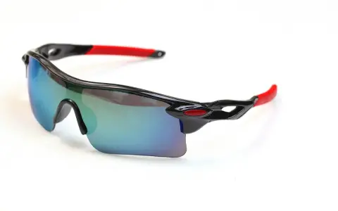 Sportowe okulary rowerowe z lustrzanymi soczewkami i czerwonymi zausznikami. Idealne, gdy zastanawiasz się, jakie okulary na rower wybrać.