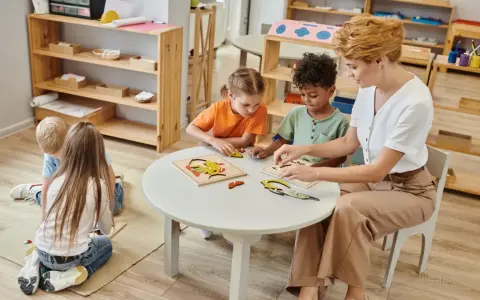 Maestra ayuda a niños de 3-4 años con rompecabezas, abordando posibles problemas de conducta con paciencia y actividades educativas.