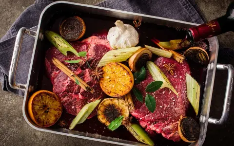 Råstekta köttbitar med apelsin, lök, vitlök och stjärnanis i en form. Ett perfekt minutfile recept för en festmåltid.