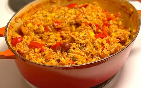 En orange gryta fylld med en smakrik jambalaya, full av ris, majs, paprika och korv. Ett perfekt recept för en mysig middag.