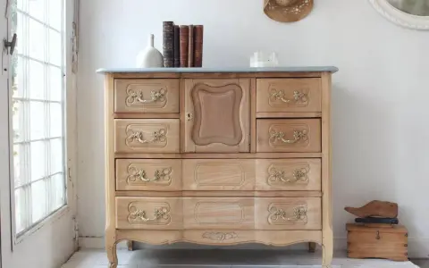 Muebles pintados a la tiza antes y después: cómoda de madera clara con tiradores dorados, lista para un nuevo look.