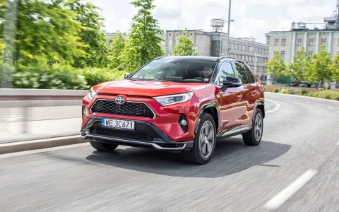 Czerwona Toyota RAV4 Hybrid na drodze miejskiej.