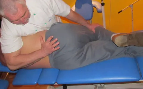 Fizjoterapeuta wykonuje terapię manualną, pomagając pacjentowi odzyskać sprawność.