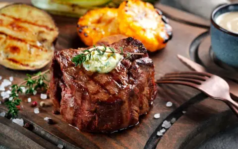 Perfekt gegrilltes Fleisch mit Kräuterbutter, dazu gegrilltes Gemüse und eine Dip-Schale.